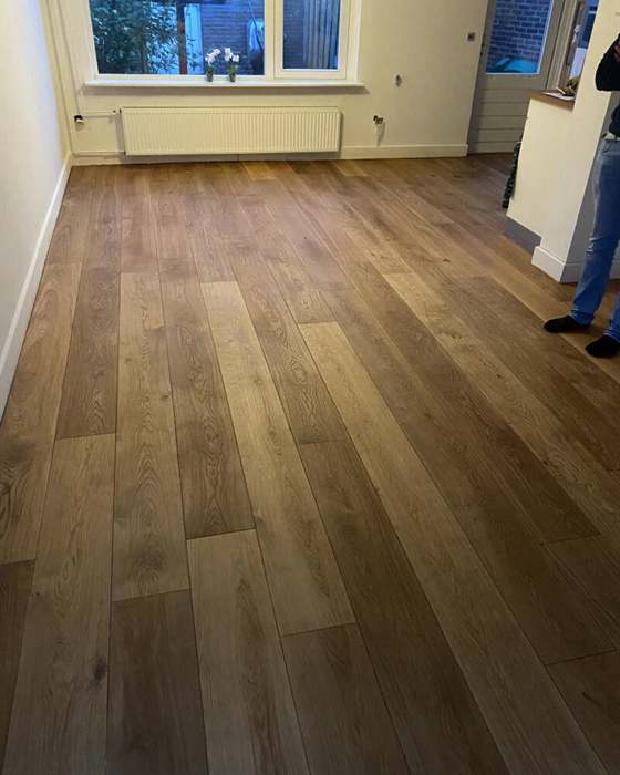 Vloer van brede donkere planken in een woonkamer
